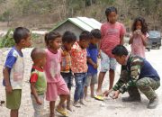 Anggota Satgas TMMD Kodim Belu Bagi-Bagi Sendal Jepit, Peduli Dengan Anak-Anak di Lokasi TMMD